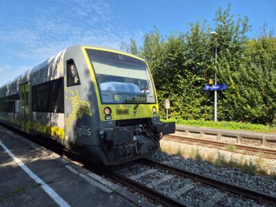 agilis Regionalbahn 97 nach Bad Steben aus nächster Nähe, im Hintergrund Schild, das auf Bahnhof Stockau verweist